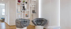 Estancia de tonos claros donde aparecen dos sillones de color gris